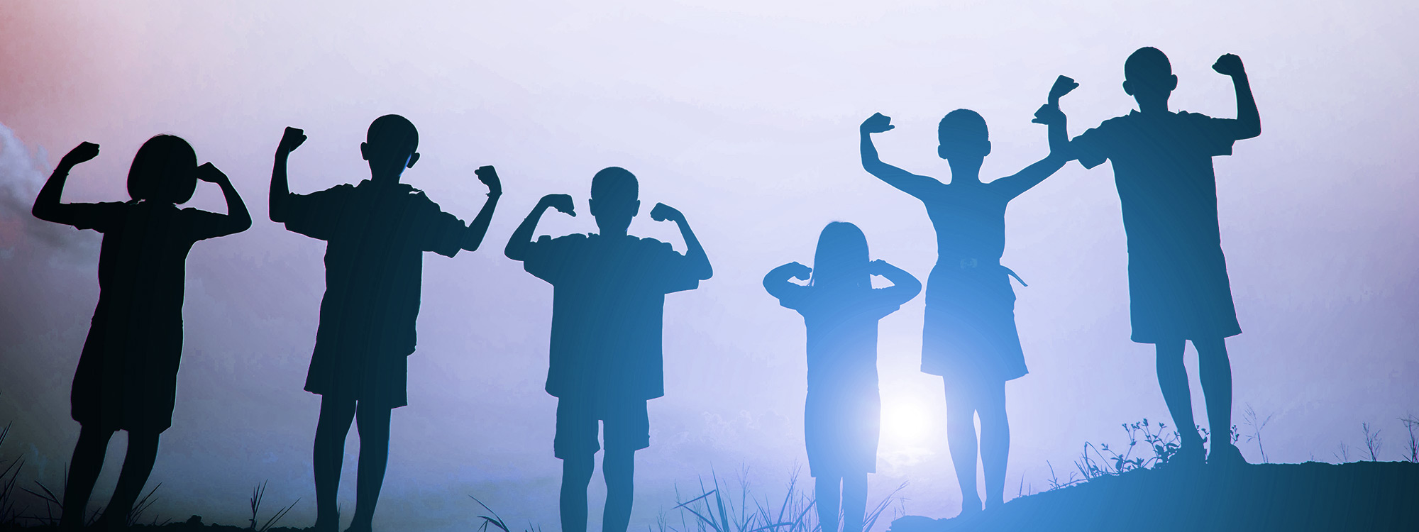 A group of children in silhouette making a flexing pose